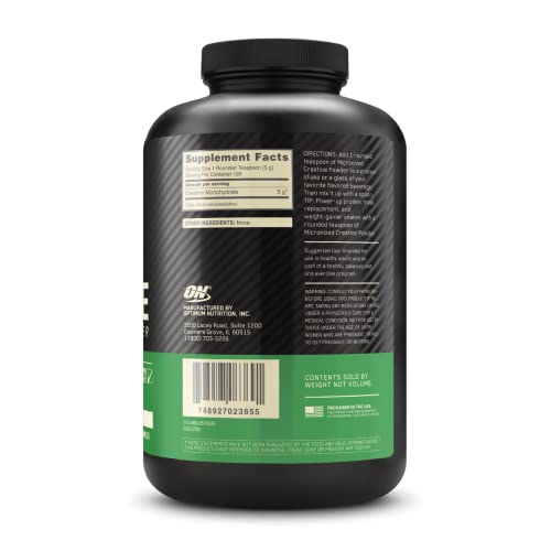 Black supplement bottle with green label on a white background