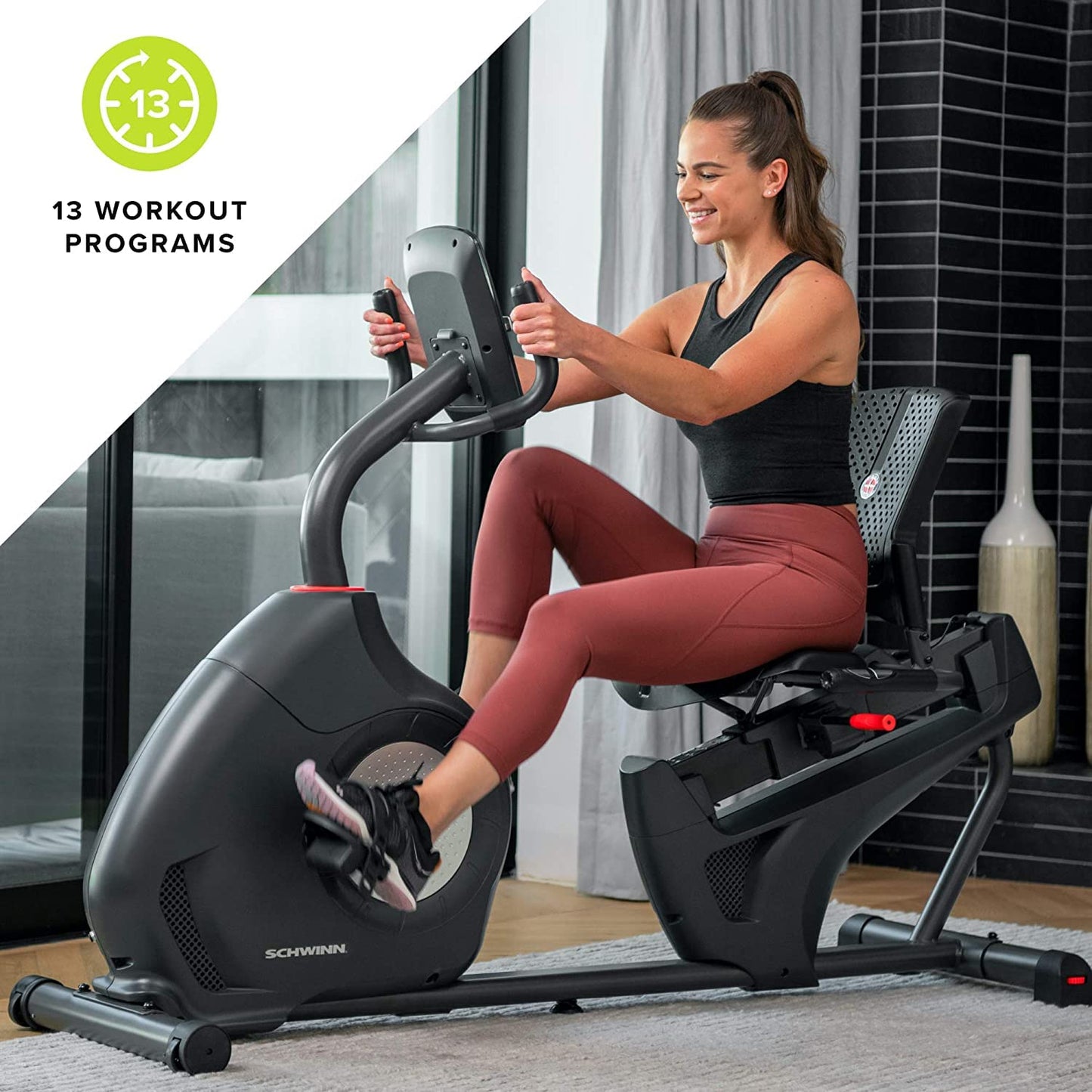 Woman exercising on a Schwinn recumbent bike in a home setting with '13 Workout Programs' text.