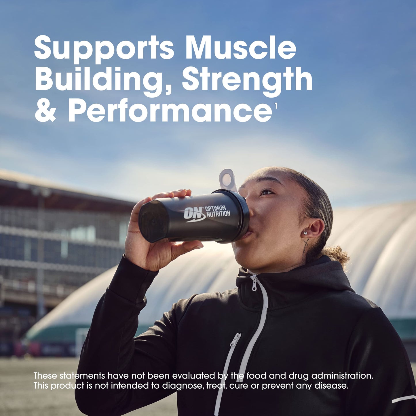 Person drinking from a Dymatize Nutrition shaker bottle with text about muscle building, strength, and performance.