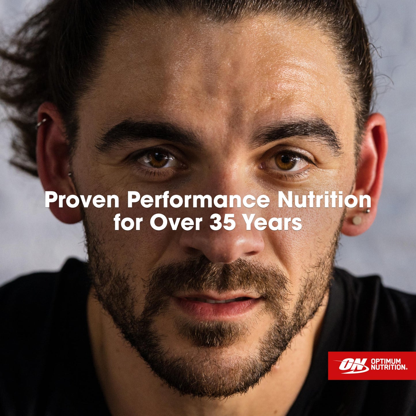 Man with beard and mustache looking directly at camera with 'Proven Performance Nutrition for Over 35 Years' text and Optimum Nutrition logo.