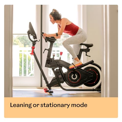 Woman exercising on a stationary bike indoors with a window in the background