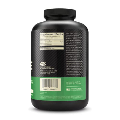 Black supplement bottle with green label on a white background