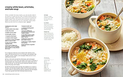 Bowls of creamy white bean, artichoke, and kale soup on a wooden surface with a recipe text overlay.