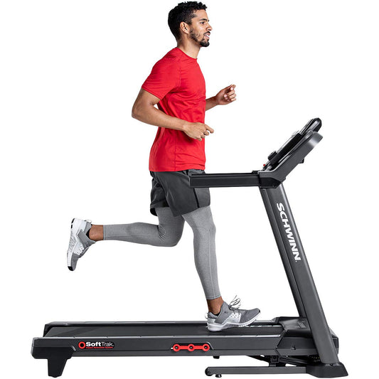 Man running on a Schwinn treadmill with a white background