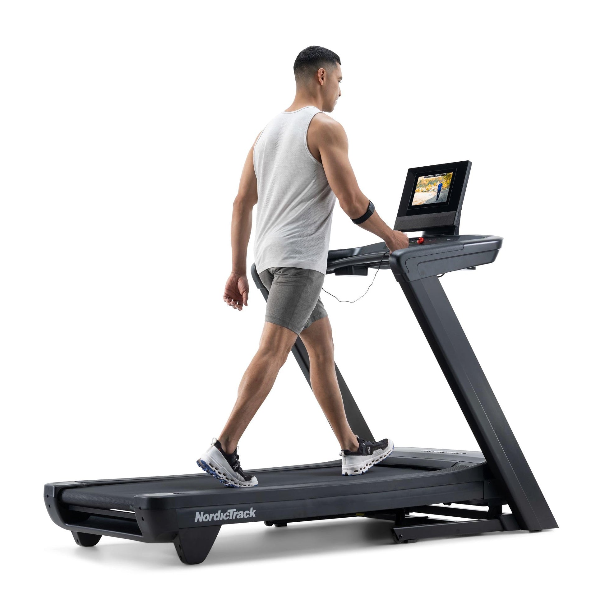 Man using a treadmill with a laptop on a white background