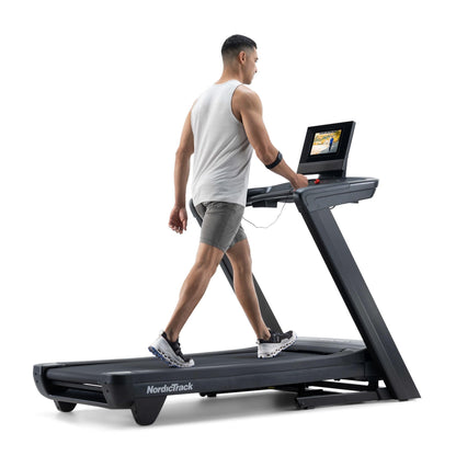 Man using a treadmill with a laptop on a white background