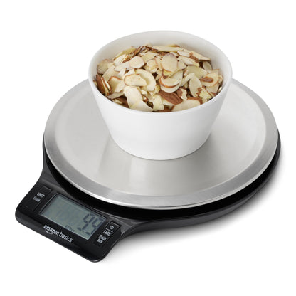 Digital kitchen scale with a bowl of almonds on a white background