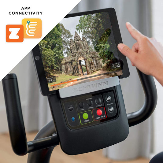 Ergometer with digital display showing a temple image and a hand interacting with it, featuring Schwinn branding.