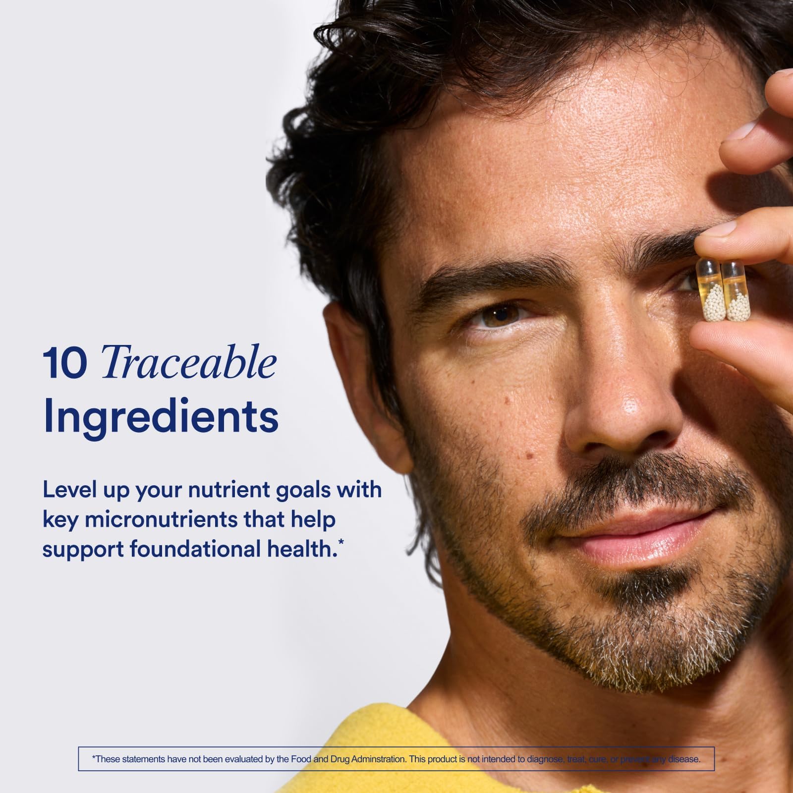 Man holding a supplement capsule with text about traceable ingredients on a light gray background