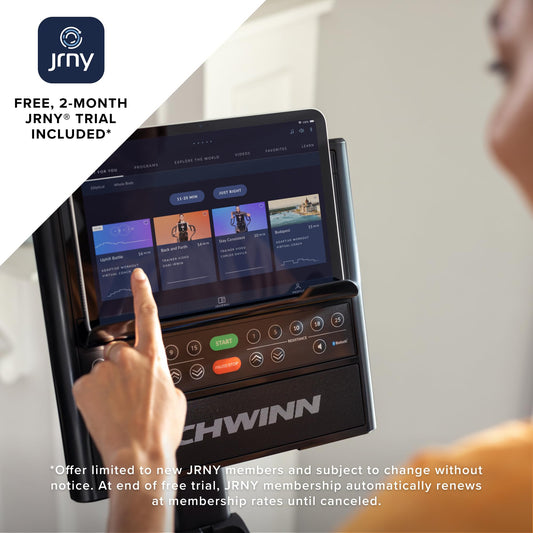 Person using a Schwinn bike console with JRNY app interface on screen