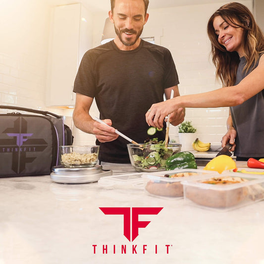 Two people preparing a salad in a kitchen with ThinkFit branding.