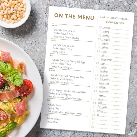 Menu planning sheet with a plate of pasta and vegetables on a gray surface