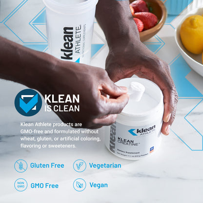 Klean Athlete product with hands holding containers on a table with fruits.