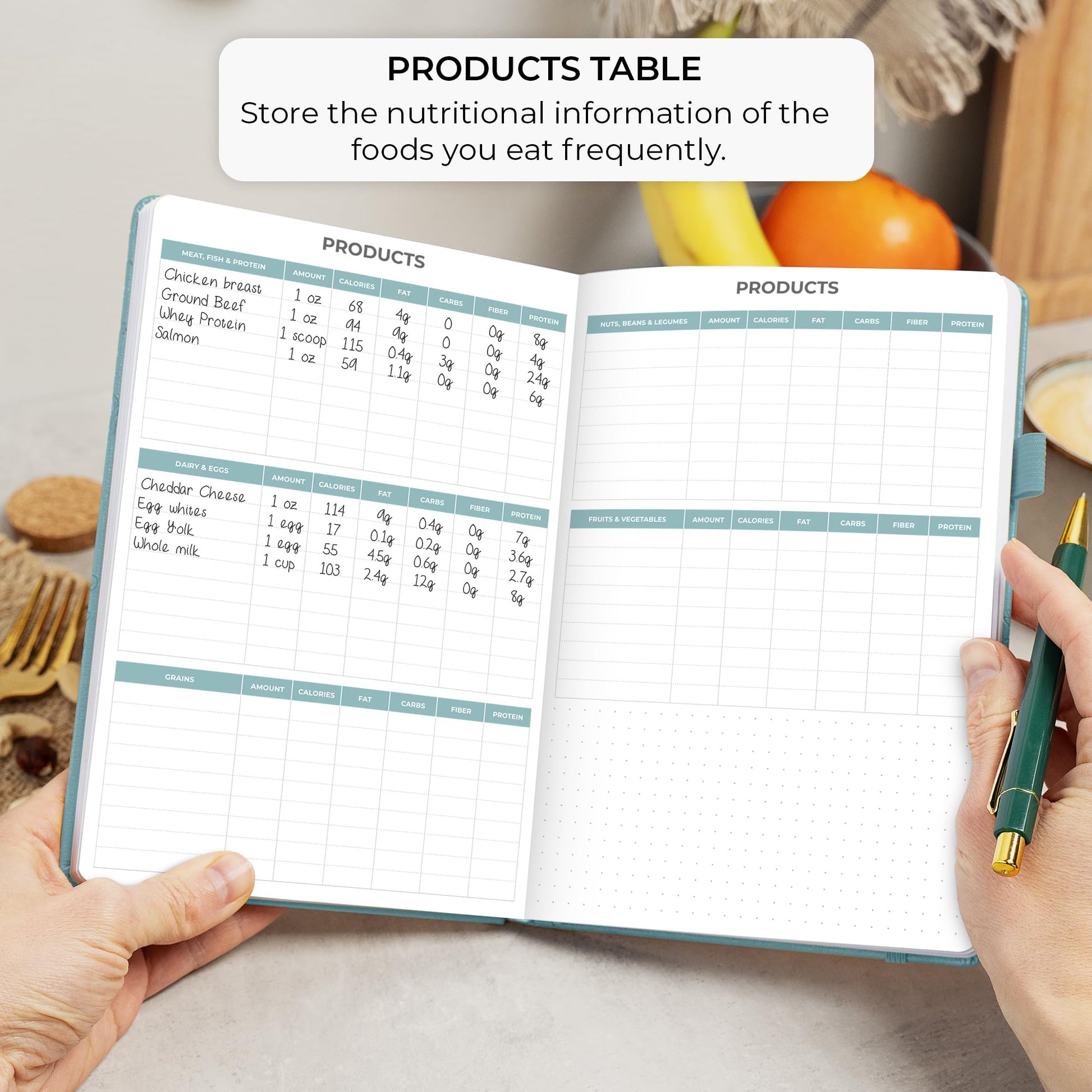 Open notebook with nutritional information pages held by a person, surrounded by fruits and a pen.