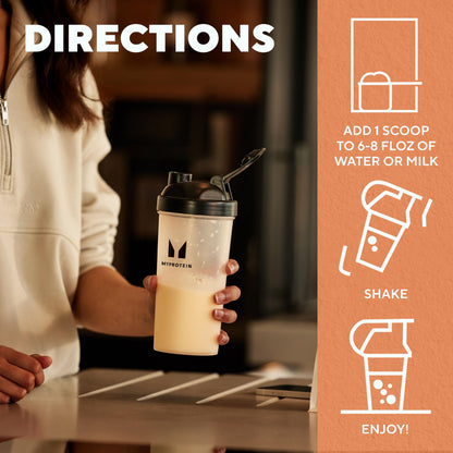 Person holding a protein shake cup with directions on an orange background