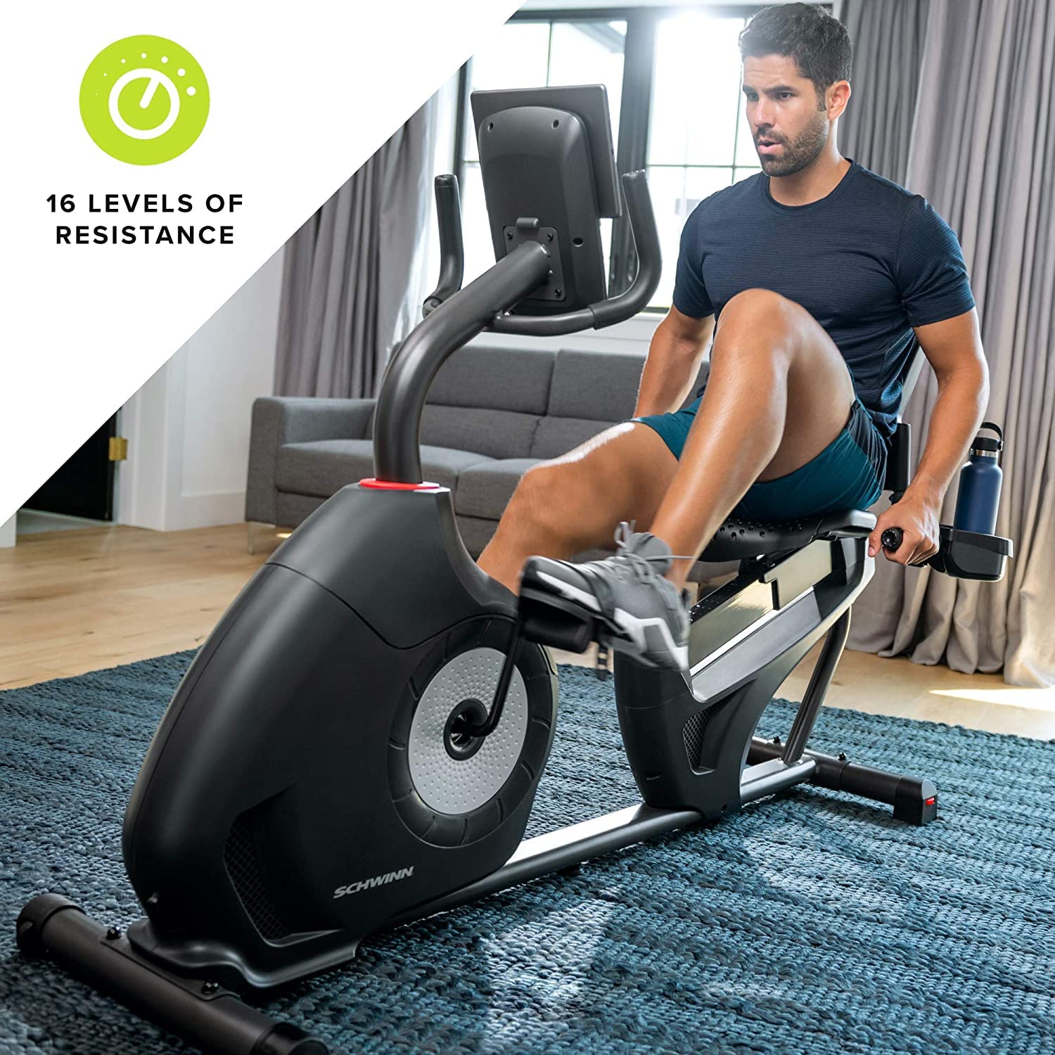 Man exercising on a Schwinn recumbent bike in a home setting with resistance levels displayed.