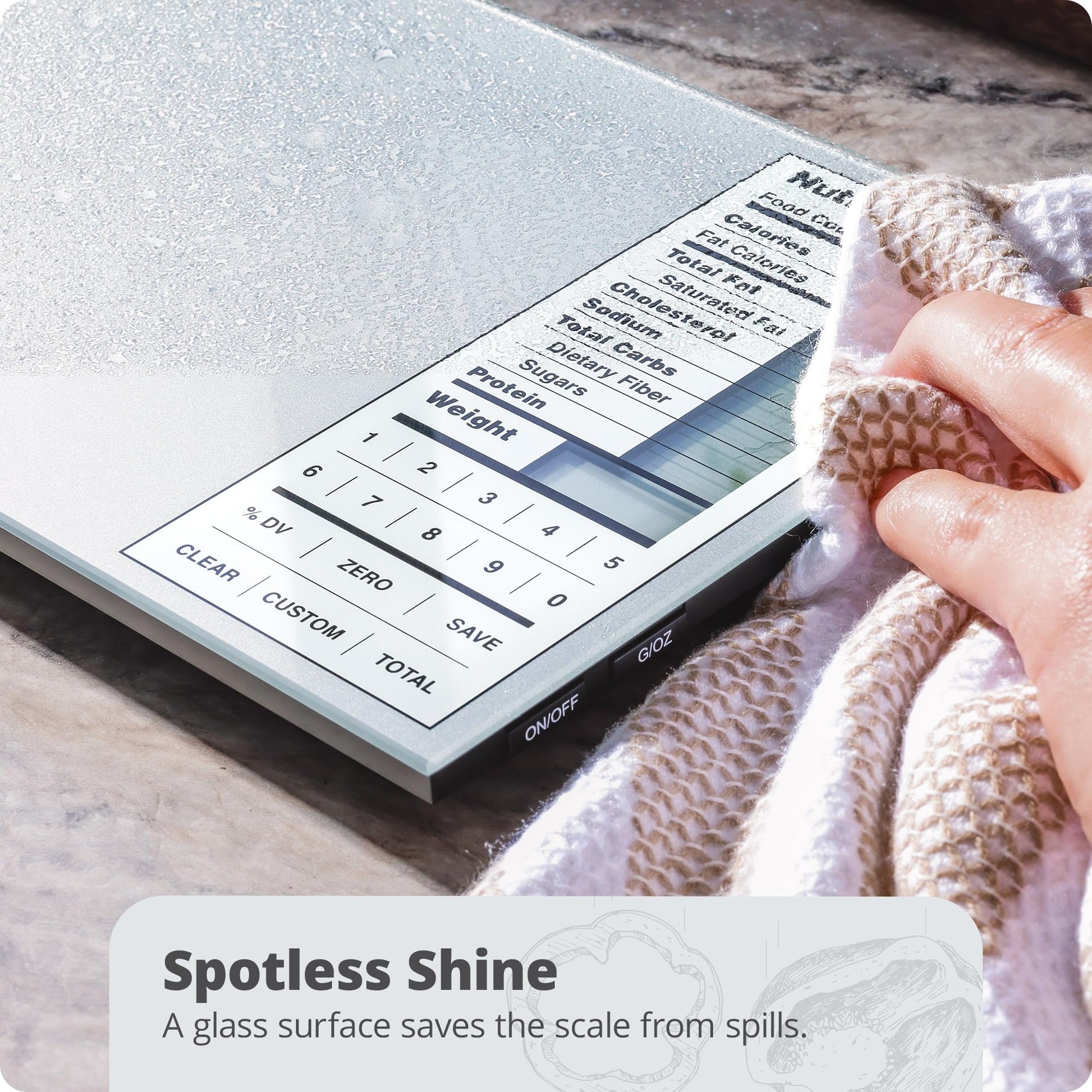 Digital kitchen scale with a glass surface being wiped by a hand, on a marble countertop.