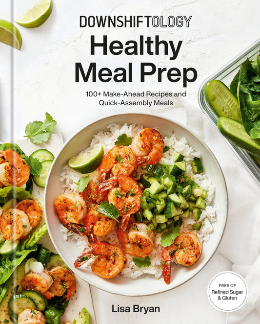 Book cover of 'Downshiftology Healthy Meal Prep' with a dish of shrimp and vegetables on a white background.
