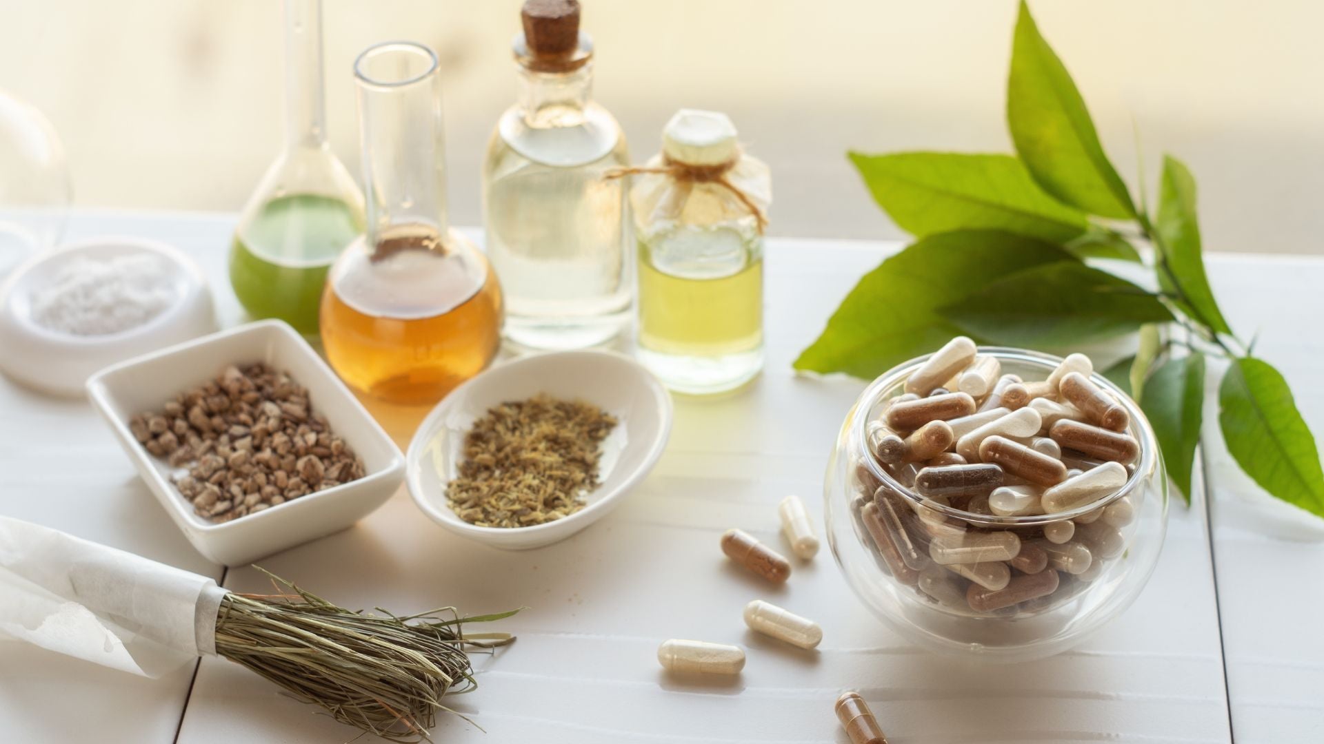 Herbal remedies including bottles, leaves, and containers on a white surface