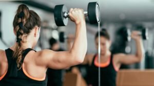 See our Exercise Solutions Woman lifting dumbbells in the gym as part of exercise solutions for weight loss and fitness