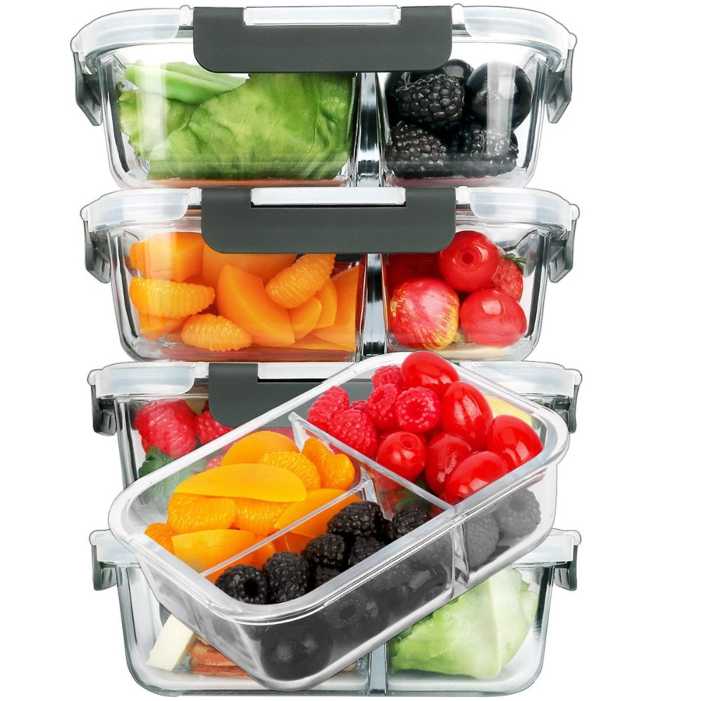 Glass meal prep containers with airtight lids and divided compartments filled with fruits and vegetables