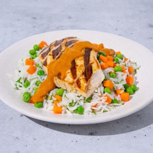 Trifecta grilled chicken with rice, peas, and carrots topped with clean sauce