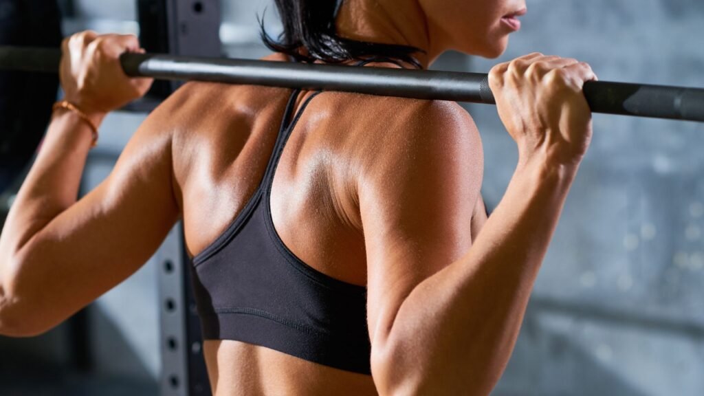 Woman performing a barbell squat in a home gym