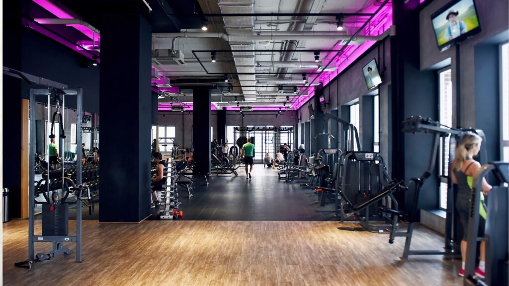 People exercising in a modern fitness club with strength and cardio equipment