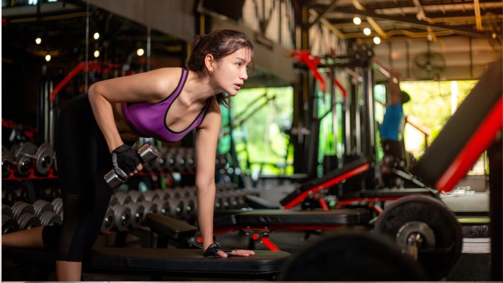 Woman training with dumbbells in a modern gym