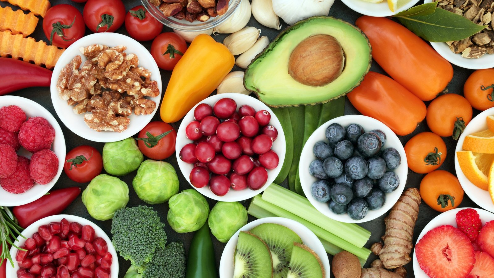 Colorful assortment of healthy fruits, vegetables, nuts, and seeds arranged for a balanced diet