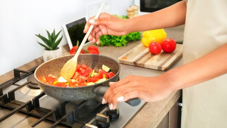 Person cooking a healthy meal with fresh vegetables in a frying pan on the stove