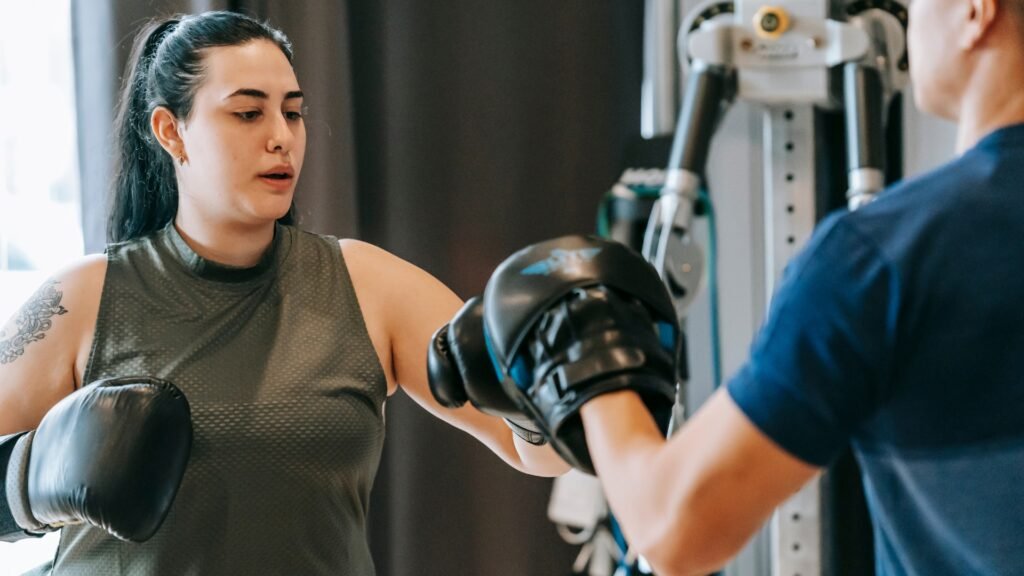 Personal trainer guiding client through boxing workout for fitness